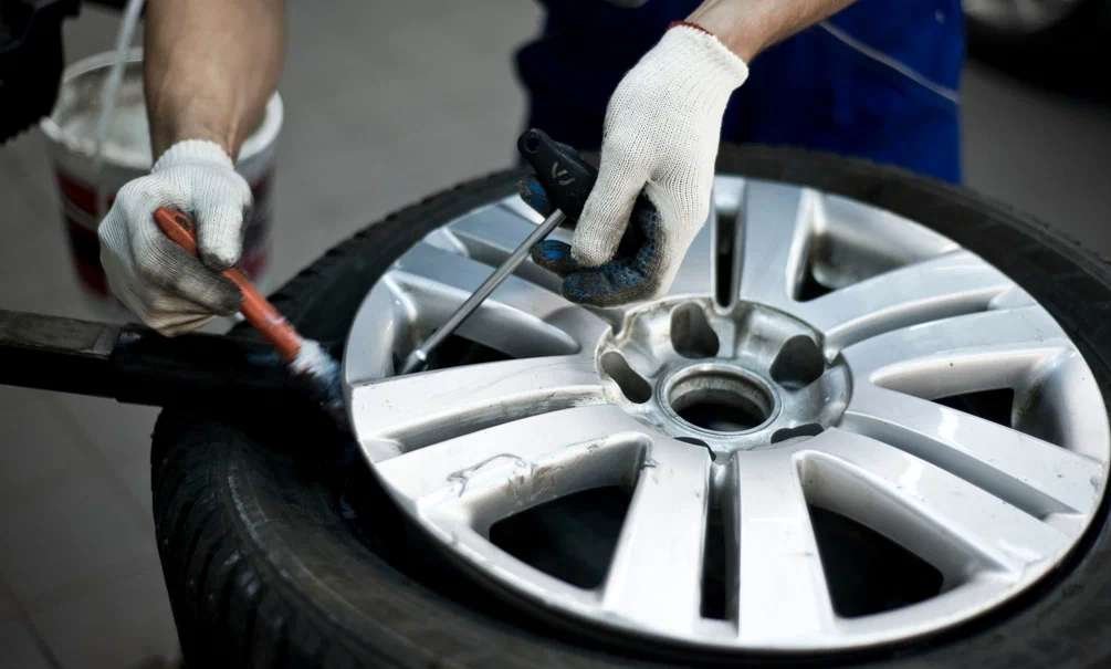 Technician checking car tyre and rim at a tyre shop in Muscat